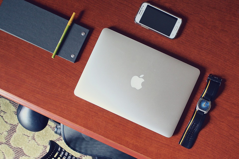 laptop, smartfon i zegarek na biurku